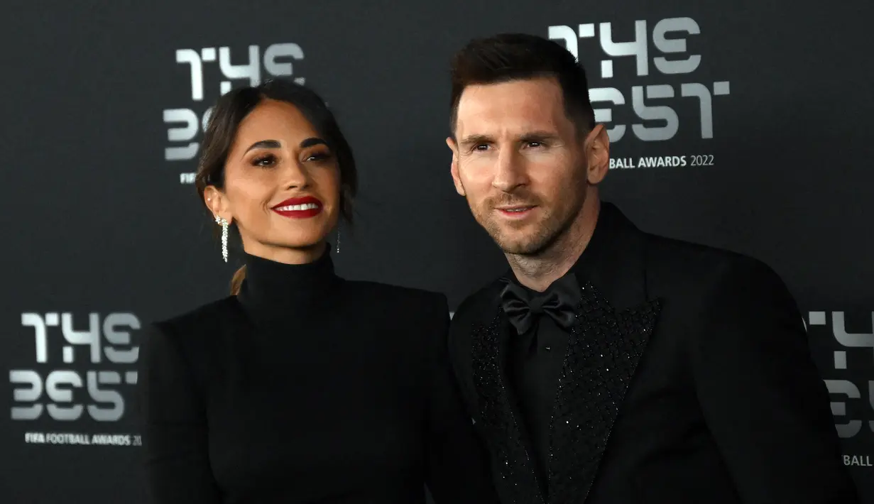 Pemain Paris Saint-Germain asal Argentina, Lionel Messi (kanan) dan istrinya Antonela Roccuzzo berpose setibanya pada acara The Best FIFA Football Awards 2022 di Paris, Prancis, 27 Februari 2023. Antonella tampil sangat cantik dan anggun daripada biasanya. (FRANCK FIFE/AFP)