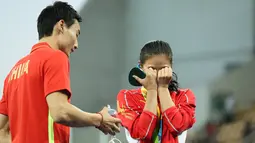 Atlet loncat indah Putri asal Tiongkok, He Zi terharu saat dilamar kekasihnya Qin Kia di atas panggung, saat pengalungan medali perak di ajang Lompat Indah 3 meter pada Olimpiade 2016 di Rio de Janeiro, Brasil, (14/8). (REUTERS/Stefan Wermuth)