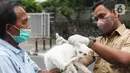 Petugas menyutikan vaksin rabies kepada kucing di Pasar Barito, Jakarta, Senin (28/3/2022). Sudin KPKP Jakarta Selatan melakukan inspeksi kesehatan hewan di Pasar Barito meliputi penyemprotan disinfektan, pemeriksaan kesehatan hewan dan vaksinasi rabies gratis. (Liputan6.com/Herman Zakharia)