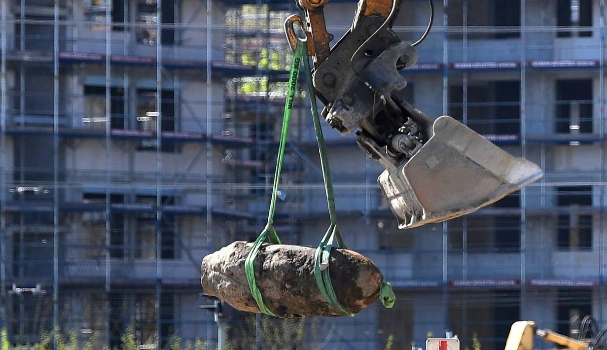Alat berat mengangkat bom perang dunia II di Berlin, Jerman, Jumat (20/4). Petugas bahkan terpaksa mengevakuasi ribuan orang dari stasiun kereta utama di kota tersebut. (Britta Pedersen / dpa via AP)