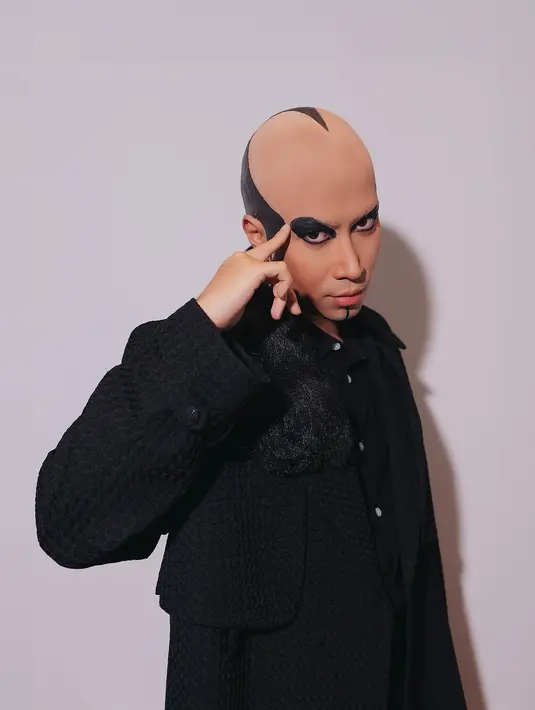 Vidi Aldiano tampil totalitas meniru gaya ikonik Deddy Corbuzier saat masih aktif sebagai pesulap. Dengan kepala setengah botak, Vidi Aldiano aplikasikan eyeliner tebal dan set jubah berwarna hitam [@vidialdiano]