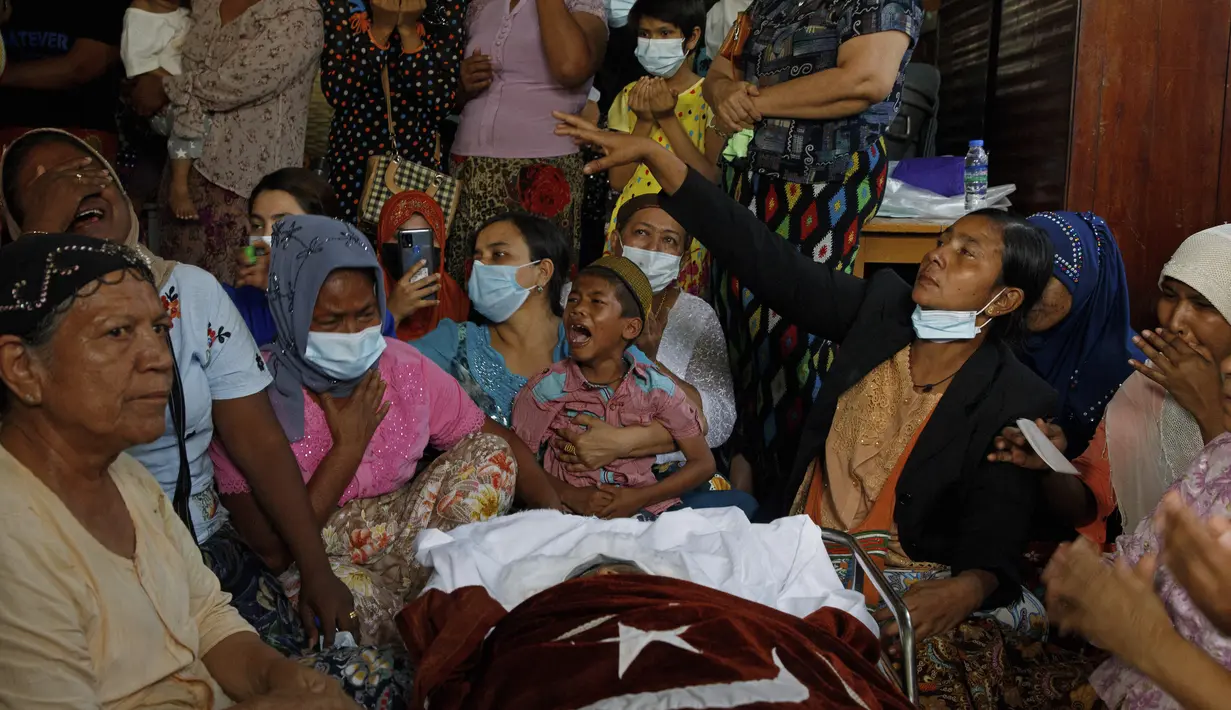 Anggota keluarga dan kerabat berdoa di samping jenazah wanita Muslim yang menurut keluarganya dibunuh oleh tentara hari Minggu saat ikut demonstras menentang kudeta militer Myanmar, saat upacara pemakamannya di Mandalay, Myanmar, Senin (1/3/2021). (AFP)
