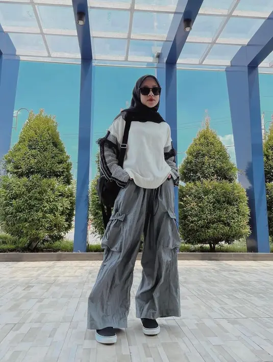 Ingin terlihat chic saat main bareng bestie? Kamu bisa memadukan celana cargo abu dengan atasan berwarna putih. Tak perlu banyak warna, kamu bisa pilih kerudung berwarna hitam agar terkesan senada [Instagram/nissa_sabyan]