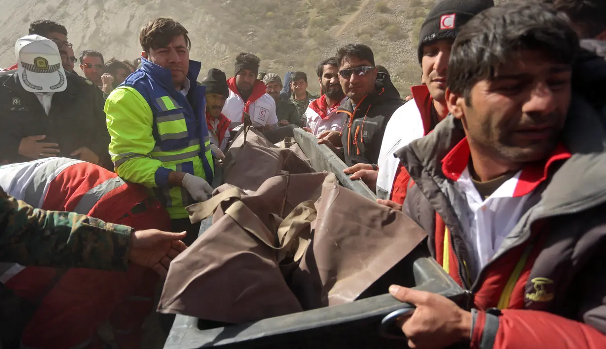 Regu penyelamat mengevakuasi jasad dari jatuhnya jet pribadi Turki yang menghantam pegunungan Zagros di Iran, Senin (12/3). Selain mengevakuasi jenazah, penyidik juga telah menemukan kotak hitam dari jet itu. (Morteza Salehi/Tasnim News Agency via AP)