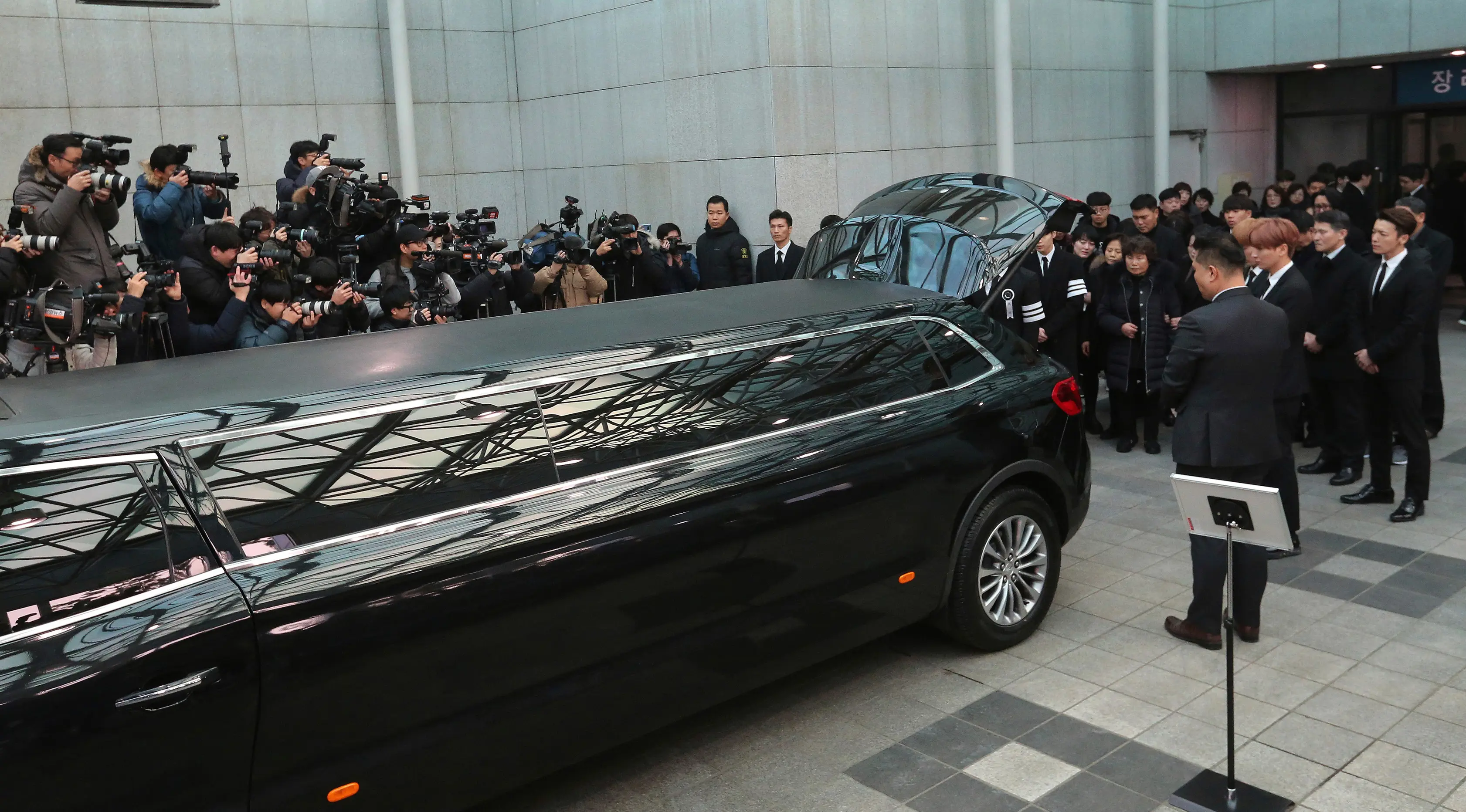 Keluarga, sahabat dan artis Korea Selatan pada prosesi pelepasan jenazah Jonghyun SHINee menuju tempat pemakaman dari Asan Hospital, Seoul, Kamis (21/12). Upacara pemakaman Jonghyun digelar tertutup dan keluarga merahasiakan lokasinya. (AP/Ahn Young-joon)