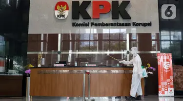 Petugas menyemprotkan cairan disinfektan di Gedung KPK, Jakarta, Selasa (22/9/2020). Penyemprotan dilakukan secara rutin untuk mengantisipasi serta menekan penyebaran virus COVID-19 menyusul temuan sedikitnya 21 kantor kementerian/lembaga yang menjadi klaster baru. (Liputan6.com/Helmi Fithriansyah)