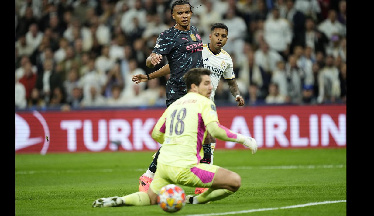 Striker Real Madrid, Rodrygo (kanan) mencetak gol kedua timnya ke gawang Manchester City pada laga leg pertama babak perempatfinal Liga Champions 2023/2024 di Santiago Bernabeu Stadium, Selasa (9/4/2024) malam. (AP Photo/Manu Fernandez)