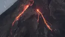 Lahar mengalir dari kawah Gunung Merapi, gunung berapi teraktif di Indonesia, terlihat dari Tunggul Arum di Yogyakarta pada 21 April 2021. Dua jalur aliran lava pijar Gunung Merapi terpantau melalui aliran Sungai Boyong dan Sungai Krasak Sleman, Yogyakarta. (AFP/Agung Supriyanto)
