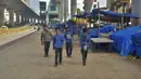 Pekerja migran berjalan melewati pasar yang tutup selama penguncian diberlakukan sebagai tindakan pencegahan terhadap penyebaran COVID-19 di Bangalore, India, Senin (24/5/2021). Kematian akibat COVID-19 di India telah menembus 300 ribu orang. (Manjunath Kiran/AFP)