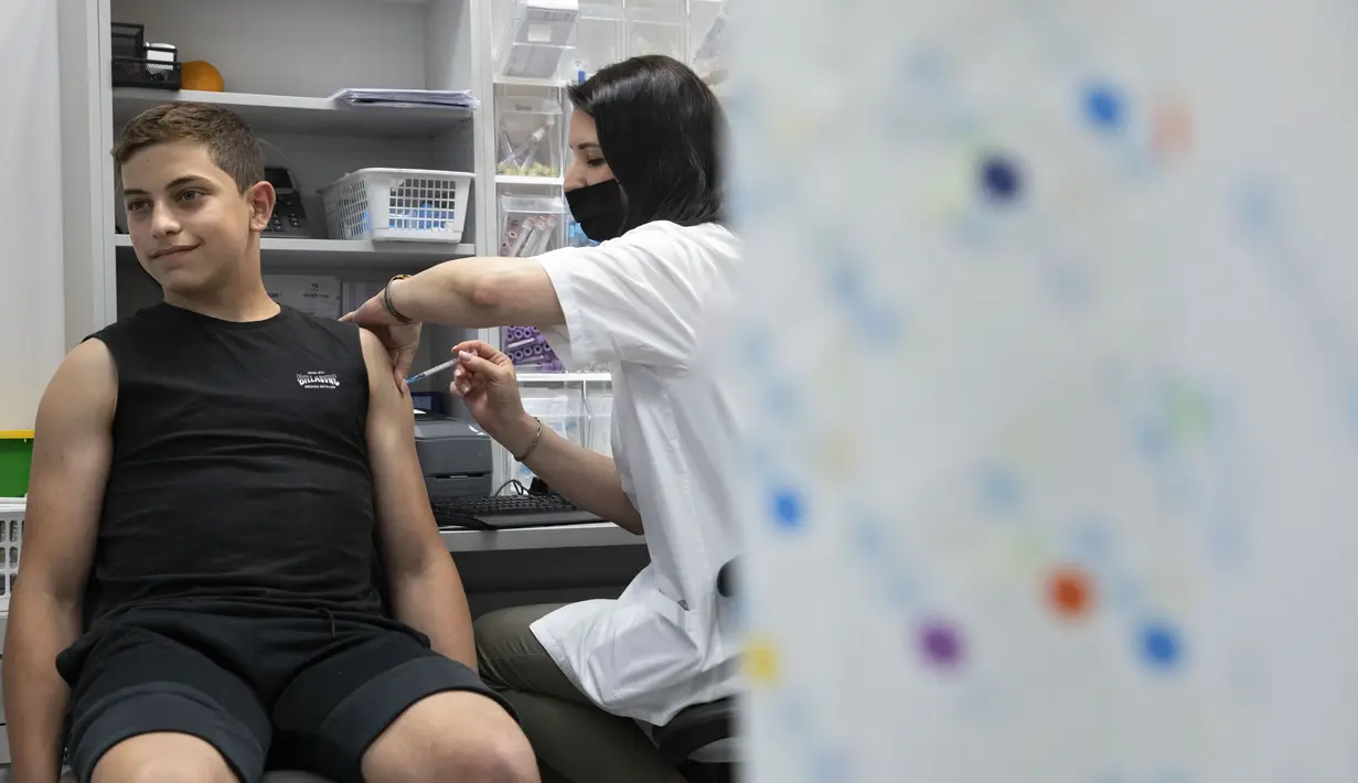 Petugas kesehatan menyuntikkan vaksin COVID-19 Pfizer-BioNTech kepada remaja Israel di kota Rishon LeZion, Minggu (6/6/2021). Israel mulai memvaksinasi anak-anak dari usia 12 hingga 15 pada hari Minggu. (AP Photo/Sebastian Scheiner)
