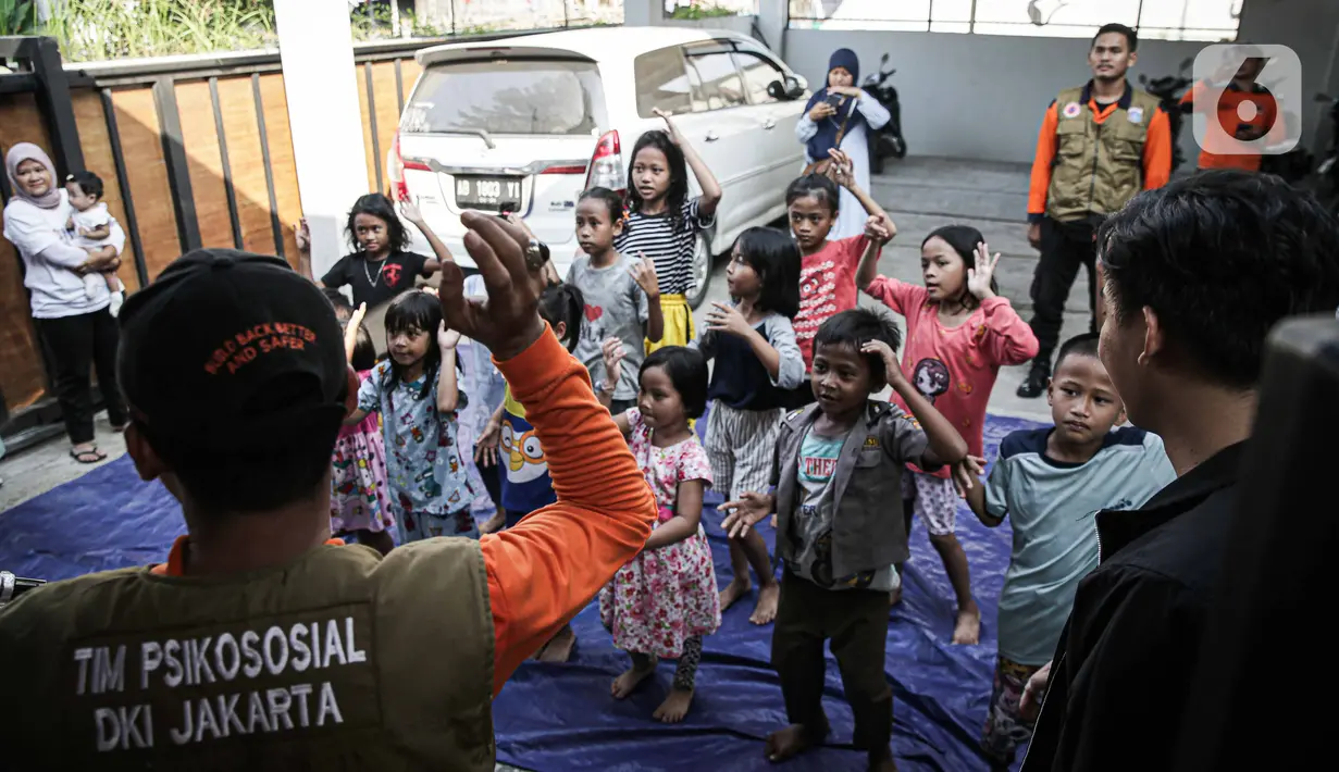 Badan Penanggulangan Bencana Daerah (BPBD) Provinsi DKI Jakarta memberikan bantuan layanan dukungan psikososial kepada anak-anak anak penyintas kebakaran Manggarai di Jalan Manggarai Utara 2, RT 01/01, Kelurahan Manggarai, Tebet, Minggu (17/12/2023). (Liputan6.com/Faizal Fanani)