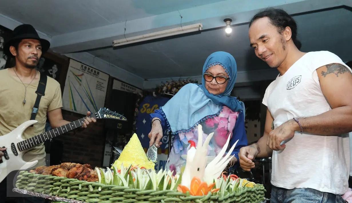 Kaka Slank mendapat potongan tumpeng dari Bunda Iffet saat merayakan ulang tahun di di Potlot, Jakarta Selatan, Jumat (10/3). Tahun 2017 ini, usai Kaka telah mencapai 43 tahun. (Liputan6.com/Herman Zakharia)
