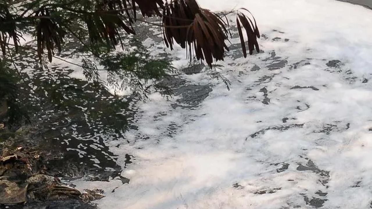 Seorang anak mencuci baju di aliran Kanal Banjir  Barat Ciliwung (KBBC) yang tercemar libah busa rumah tangga di Jakarta, Senin (23/10/2023). <br>