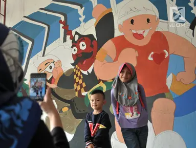 Anak-anak berpose di depan mural Wajah Baru Jakarta di terowongan Jalan Kendal, Jakarta, Kamis (20/6/2019).  Mural tersebut dibuat dalam rangka menyambut HUT ke-492 DKI Jakarta sekaligus mempercantik lingkungan. (merdeka.com/Iqbal S. Nugroho)