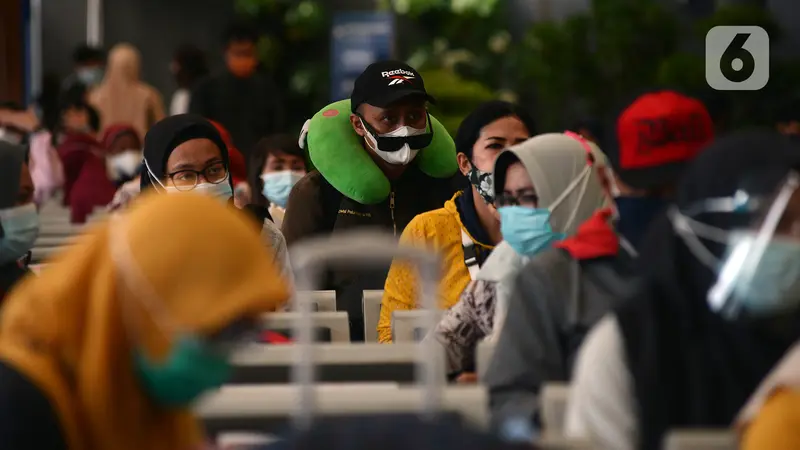 FOTO: Petugas KAI Berkostum Natal Bagikan Masker ke Calon Penumpang di Stasiun Senen