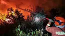 Petugas pemadam kebakaran berusaha memedamkan kebakaran hutan di Xichang, Provinsi Sichuan, China, Selasa (31/3/2020). Sebanyak 19 orang tewas dalam kebakaran hutan tersebut karena perubahan angin secara tiba-tiba. (STR/AFP)