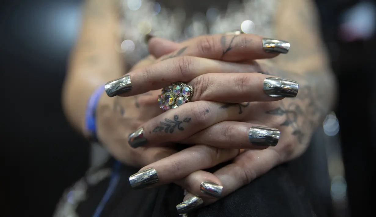 Seorang wanita berpose memamerkan tato pada tangannya dalam acara Sao Paulo Tattoo Week, Brasil, Jumat (25/10/2019). (AP Photo/Andre Penner)