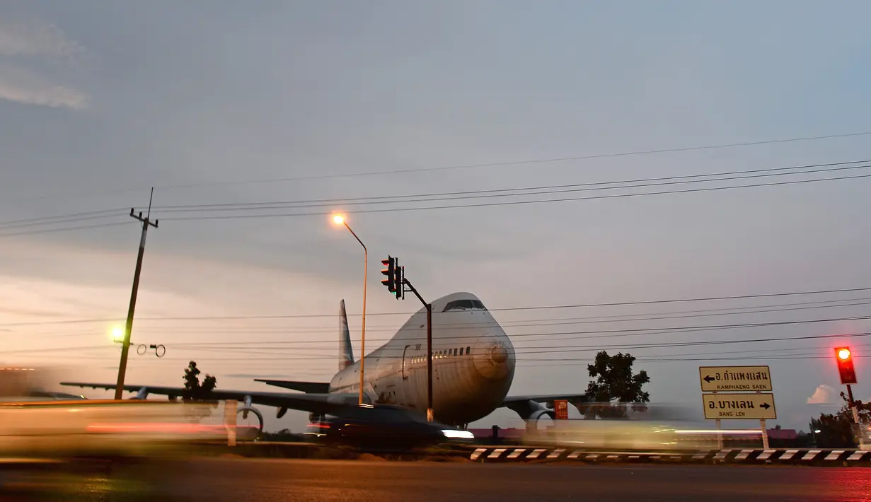 Sebuah pesawat Boeing 747 terlihat di persimpangan jalan raya Nakhon Pathom, Bangkok, Thailand (19/1). Pesawat penumpang ini tidak kembali aktif dan sengaja diletakkan dipersimpangan jalan. (AFP PHOTO / Christophe Archambault)
