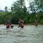 Untuk sekolah, para murid SD di sana harus rela menyebrangi sungai yang arusnya begitu deras. (Liputan6.com/Yonif 511/Dibyatara Yodha)