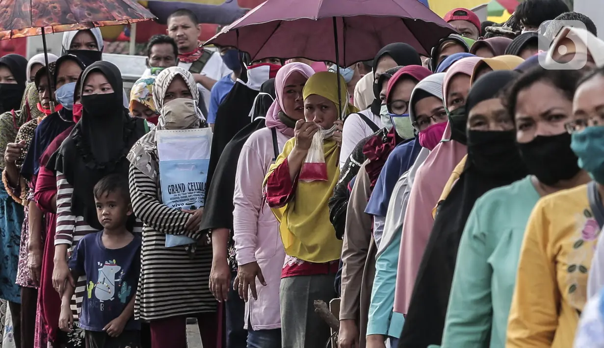 Warga antre untuk menerima Bantuan Sosial Tunai (BST) di Desa Cikande, Kecamatan Jayanti, Kabupaten Tangerang, Banten, Selasa (23/6/2020). Bantuan tersebut merupakan salah satu program jaring pengaman sosial terkait pandemi virus corona COVID-19. (Liputan6.com/Johan Tallo)