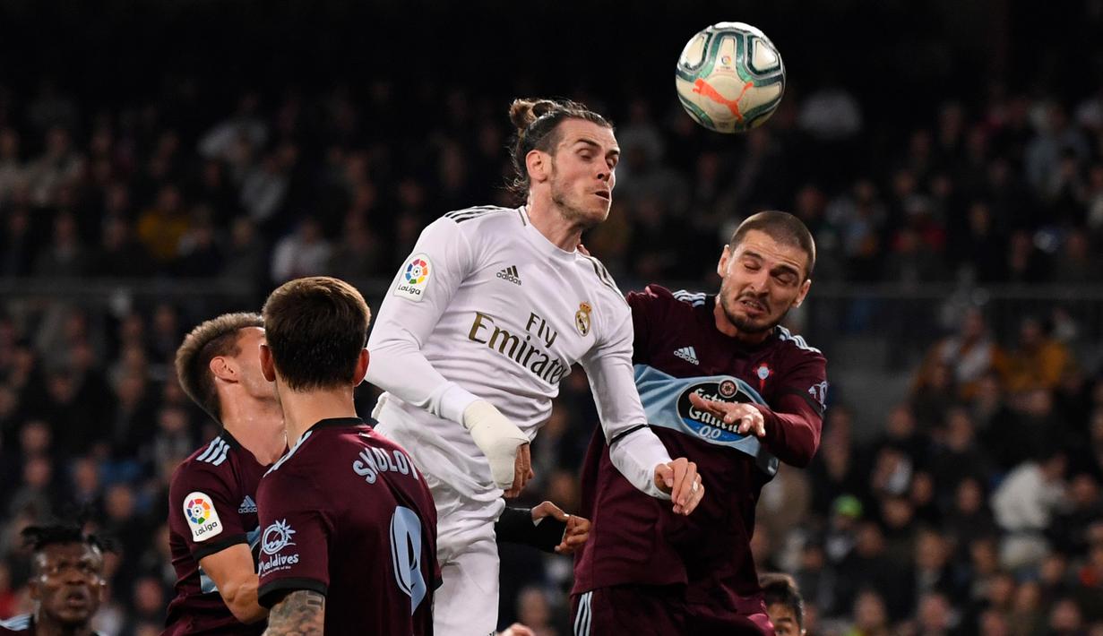 Penyerang Real Madrid, Gareth Bale berusaha menyundul bola dari kawalan para pemain Celta Vigo pada pertandingan lanjutan La Liga Spanyol di stadion Santiago Bernabeu di Madrid, Spanyol, Minggu, (16/2/2020). Madrid bermain imbang 2-2 atas Celta Vigo.  (AFP/Pierre-Philippe Marcou)