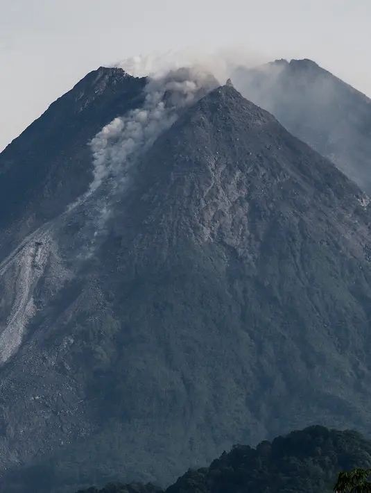 Asap mengepul dari Gunung Merapi di Yogyakarta, Sabtu (23/1/2021). Gunung Merapi juga mengalami 24 kali gempa guguran dengan amplitudo 4-23 mm selama 18.3-84.8 detik dan empat kali gempa hembusan dengan amplitudo 4-6 mm selama 12.4-18.4 detik.  (AFP/Agung Supriyanto)
