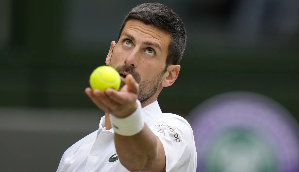 Petenis Serbia, Novak Djokovic bersiap melepaskan serve saat menghadapi petenis Spanyol, Carlos Alcaraz pada laga final tunggal putra turnamen tenis Grand Slam Wimbledon 2023 di All England Lawn and Tennis Club, London, Minggu (16/7/2023) malam WIB. (AP Photo/Kirsty Wigglesworth)