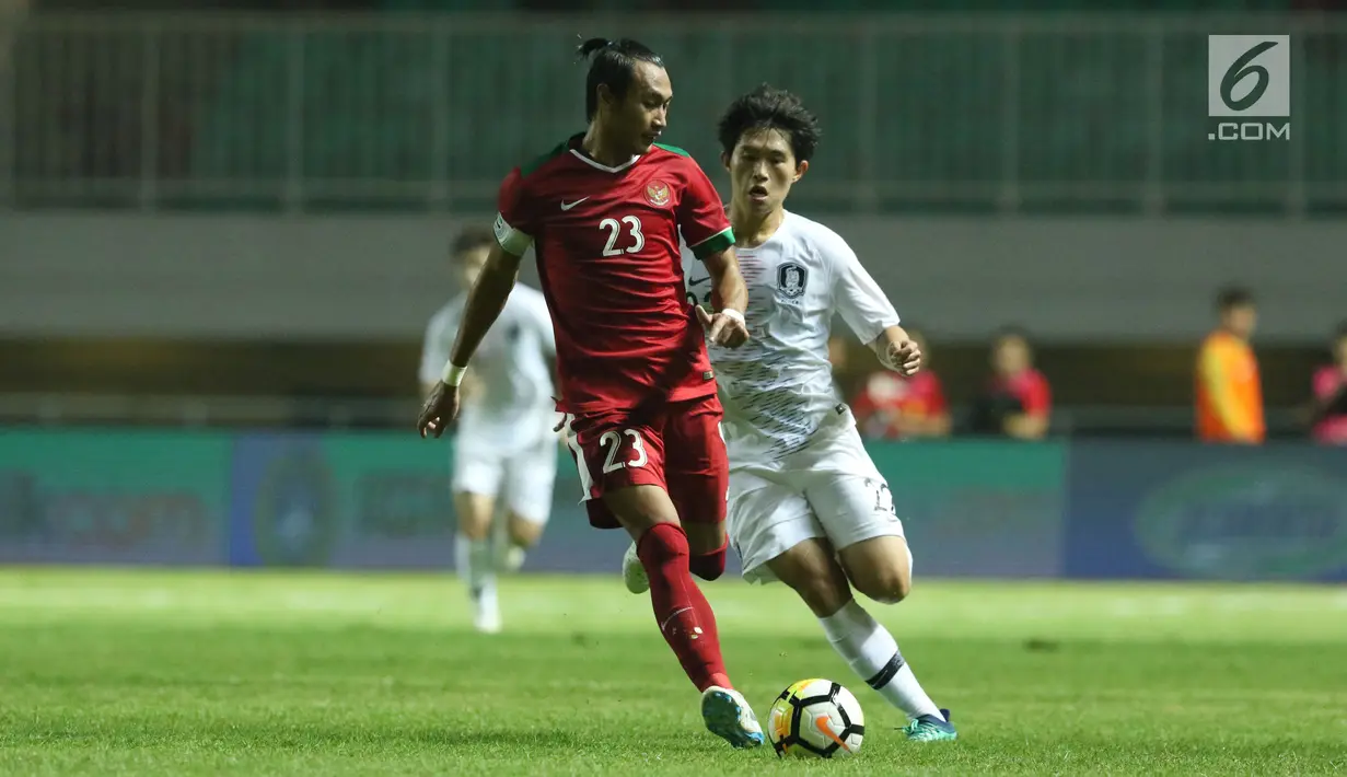Kapten Timnas Indonesia U-23. Hansamu Yama Pranata (kiri) berebut bola dengan pemain Korea Selatan U-23 pada laga persahabatan di Stadion Pakansari, Kab Bogor, Sabtu (23/6). Babak pertama Indonesia U-23 tertinggal 0-1. (Liputan6.com/Helmi Fithriansyah)