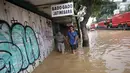 Warga berjalan melintasi banjir di Jalan Jatinegara Barat, Jakarta Timur, Selasa (6/2). Kiriman debit air dari hulu (Bogor) membuat sejumlah kawasan di bantaran Kali Ciliwung meluap(Liputan6.com/Arya Manggala)