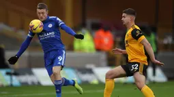 Striker Leicester City, Jamie Vardy (kiri) menguasai bola dibayangi gelandang Wolverhampton Wanderers, Leander Dendoncker dalam laga lanjutan Liga Inggris 2020/21 pekan ke-23 di Molineux Stadium, Minggu (7/2/2021). Leicester bermain imbang 0-0 dengan Wolverhampton. (AFP/Nick Potts/Pool)