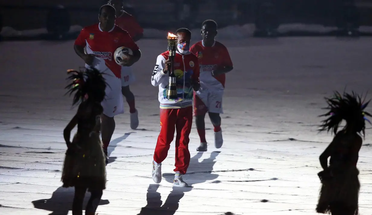 Boaz Solossa membawa obor api PON XX Papua 2021 pada acara Opening Ceremony di Stadion Utama Lukas Enembe, Kampung Harapan,Sentani, Kabupaten Jayapura, Sabtu (2/10/2021). (PB PON XX Papua 2021/Husni Yamin)