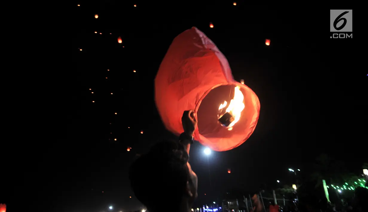 Pengunjung menerbangkan lampion saat perayaan Tahun Baru Imlek di Pantai Lagoon, Ancol, Jakarta, Selasa (5/2) malam. Sebanyak 500 lampion diterbangkan oleh pengunjung dalam  rangka menutup Festival Imlek di Ancol. (Merdeka.com/Iqbal S Nugroho)