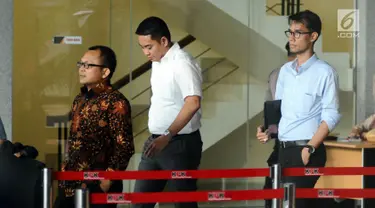 Politisi Partai Golkar, Fayakhun Andriadi (tengah) tertunduk saat meninggalkan Gedung KPK, Jakarta, Rabu (27/12). Fayakhun dimintai keterangan sebagai saksi dugaan suap pengadaan alat satelit monitoring di Bakamla-RI. (Liputan6.com/Helmi Fithriansyah)