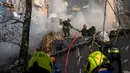 Petugas pemadam kebakaran bekerja setelah sebuah pesawat tak berawak menghantam gedung-gedung di Kyiv, Ukraina, Senin (17/10/2022).  Pesawat tak berawak menghantam sejumlah gedung ibu kota Ukraina pada Senin pagi ledakan tesebut menggema di seluruh Kyiv dan menimbulkan kepanikan sehingga orang-orang berlarian ke lokasi yang aman.  (AP Photo/Roman Hrytsyna)