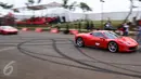 Mobil Ferrari melaju kencang mengelilingi sirkuit dalam Ferrari Festival of Speed di BSD City, Tangsel, Minggu (23/4). Pemilik mobil Ferrari yang mengikuti parade berdatangan dari Jakarta, Bandung, Surabaya, Malang dan Bali. (Liputan6.com/Fery Pradolo)
