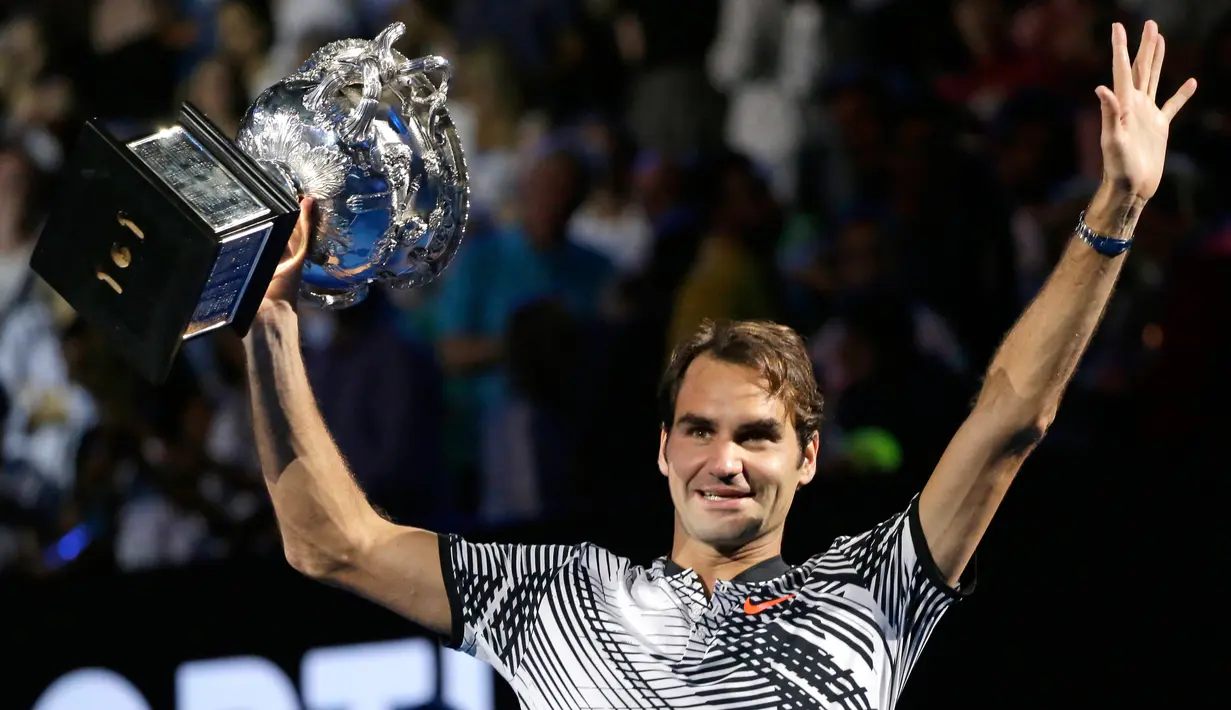 Petenis asal Swiss Roger Federer, memegang pialanya setelah mengalahkan Rafael Nadal asal Spanyol pada Final Australia Terbuka 2017 di Melbourne, Minggu (29/1). Gelar ini merupakan gelar Grand Slam ke-18 sepanjang kariernya. (AP Photo/Aaron Favila)