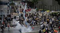 Pengunjuk rasa menghindari gas air mata yang ditembakan oleh polisi anti huru hara di luar gedung Dewan Legislatif, Hong Kong, Rabu (12/6/2019). Polisi Hong Kong telah menggunakan gas air mata ke arah ribuan demonstran yang menentang RUU ekstradisi yang sangat kontroversial. (AP Photo/Vincent Yu)