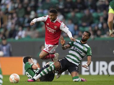 Pemain Arsenal, Reiss Nelson (tengah) berusaha melewati pemain Sporting CP pada laga leg pertama Liga Europa 2022/2023 di Jose Alvalade Stadium, Lisbon, Jumat (10/03/2023) dini hari WIB. Laga berakhir dengan skor imbang 2-2. (AP Photo/Armando Franca)
