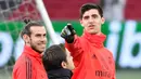 Pemain Real Madrid Gareth Bale (kiri) berbincang dengan Thibaut Courtois saat sesi latihan jelang menghadapi Ajax Amsterdam pada babak 16 besar Liga Champions di Johan Cruijff Arena, Amsterdam, Belanda, Selasa (12/2). (EMMANUEL DUNAND/AFP)