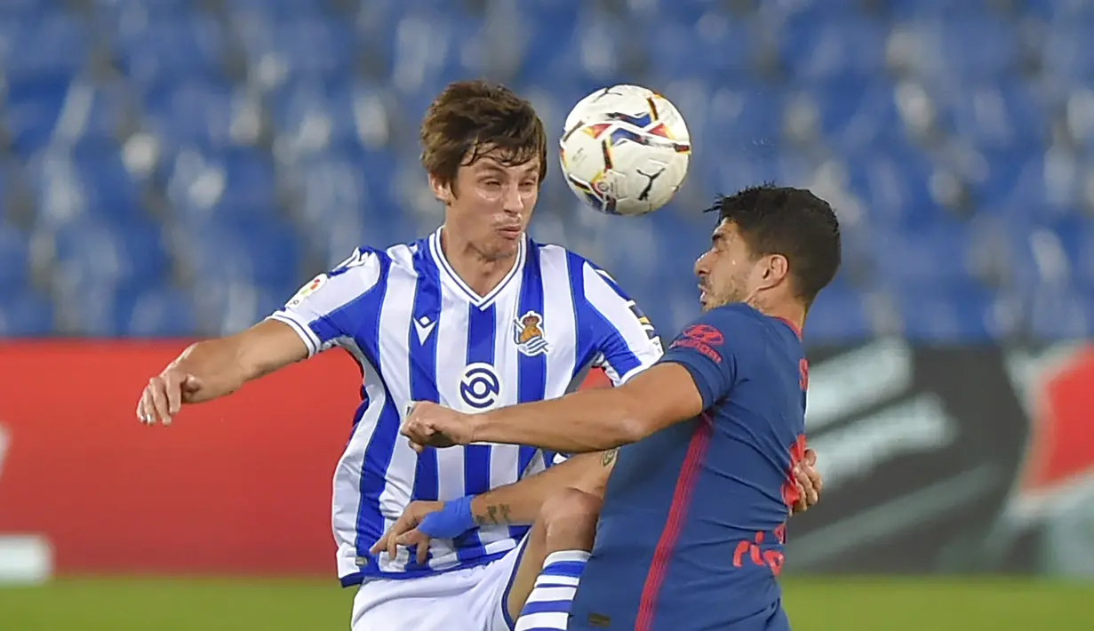 Penyerang Atletico Madrid, Luis Suarez, berebut bola dengan bek Real Sociedad, Robin Le Normand, pada laga lanjutan Liga Spanyol di Anoeta Stadium, Rabu (23/12/2020) dini hari WIB. Atletico Madrid menang 2-0 atas Real Sociedad. (AFP/Ander Gillenea)