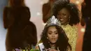 Miss District of Columbia, Kara McCullough bereaksi saat disematkan mahkota Miss USA 2017 di Las Vegas, Minggu (14/5). Di ajang yang memasuki tahun ke-66, Kara berhasil menyisihkan 50 kontestan dari seluruh penjuru Amerika. (AP Photo/John Locher)