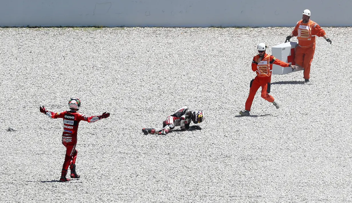 Francesco Bagnaia (kiri) yang awalnya berusaha menahan agar tidak jatuh, akhirnya juga ikut dalam insiden tersebut. (AP/Joan Monfort)