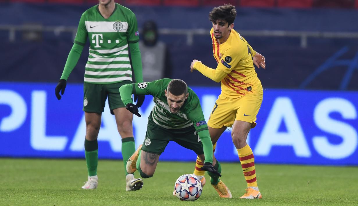 Penyerang Barcelona, Francisco Trincao, berebut bola dengan bek Ferencvaros, Marcel Heister, pada laga lanjutan Liga Champions di Puskas Arena, Kamis (3/12/2020) dini hari WIB. Barcelona menang 3-0 atas Ferencvaros. (AFP/Attila Kisbenedek)
