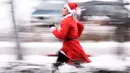 Seorang wanita berpakaian Sinterklas mengambil bagian dalam Santa Claus Run di Pristina, Kosovo, Minggu (16/12). Ratusan pelari berpartisipasi dalam lomba lari amal untuk menggalang dana bagi keluarga yang membutuhkan di Kosovo. (Armend NIMANI/AFP)