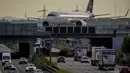 Sebuah pesawat Lufthansa meluncur ke bandara di atas jalan raya di Frankfurt, Jerman, Selasa (26/7/2022). Lebih dari 130 ribu penumpang diprediksi terpengaruh dengan pembatalan penerbangan ini. Kemungkinan, pembatalan penerbangan bakal masih terjadi hingga Jumat. (AP Photo/Michael Probst)