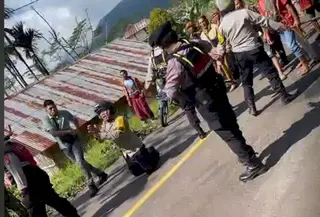 Anggota Polisi NTT Aipda Arkadius Modestus Arno berlutut di tengah massa bentrok (tangkapan layar Facebook @Hendrik Ilo)