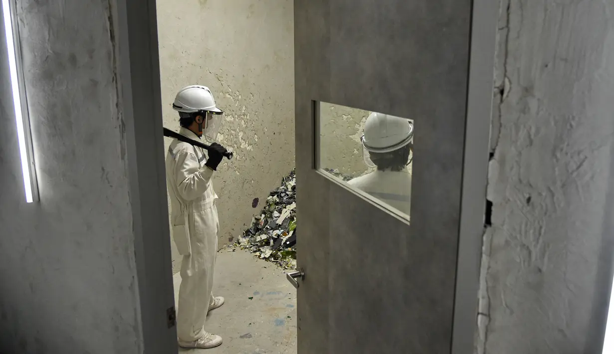 Dua orang memukul botol di "rage room" atau ruang kemarahan di Singapura (19/10). Para karyawan bisa melampiaskan kemarahan mereka dengan memukul, melempar barang-barang dari botol hingga televisi. (AFP Photo/Roslan Rahman)