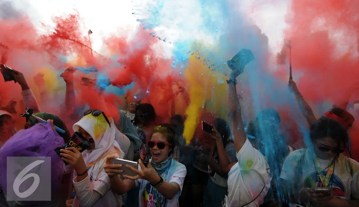 Beragam warna dilempar ke udara saat puncak gelaran Colour Run 2016 di Parkir Timur Senayan, Jakarta, Minggu (7/8). Tampak sejumlah muda mudi berpesta warna pada puncak event lari santai 5K Colour Run 2016. (Liputan6.com/Helmi Fithriansyah)