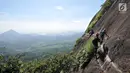 Pendaki memanjat tebing Gunung Parang via Jalur Ferrata, Desa Cihuni, Purwakarta, Jawa Barat, Sabtu (30/3). Gunung Parang menjadi lokasi wisata panjat tebing tertinggi kedua di Asia. (merdeka.com/Iqbal Nugroho)