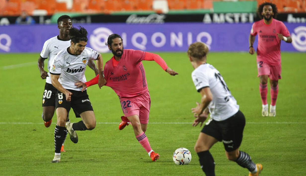 Pemain Real Madrid, Isco, berusaha melewati pemain Valencia pada laga Liga Spanyol di Stadion Mestalla, Minggu (8/11/2020). Valencia menang dengan skor 4-1. (AP/Alberto Saiz)